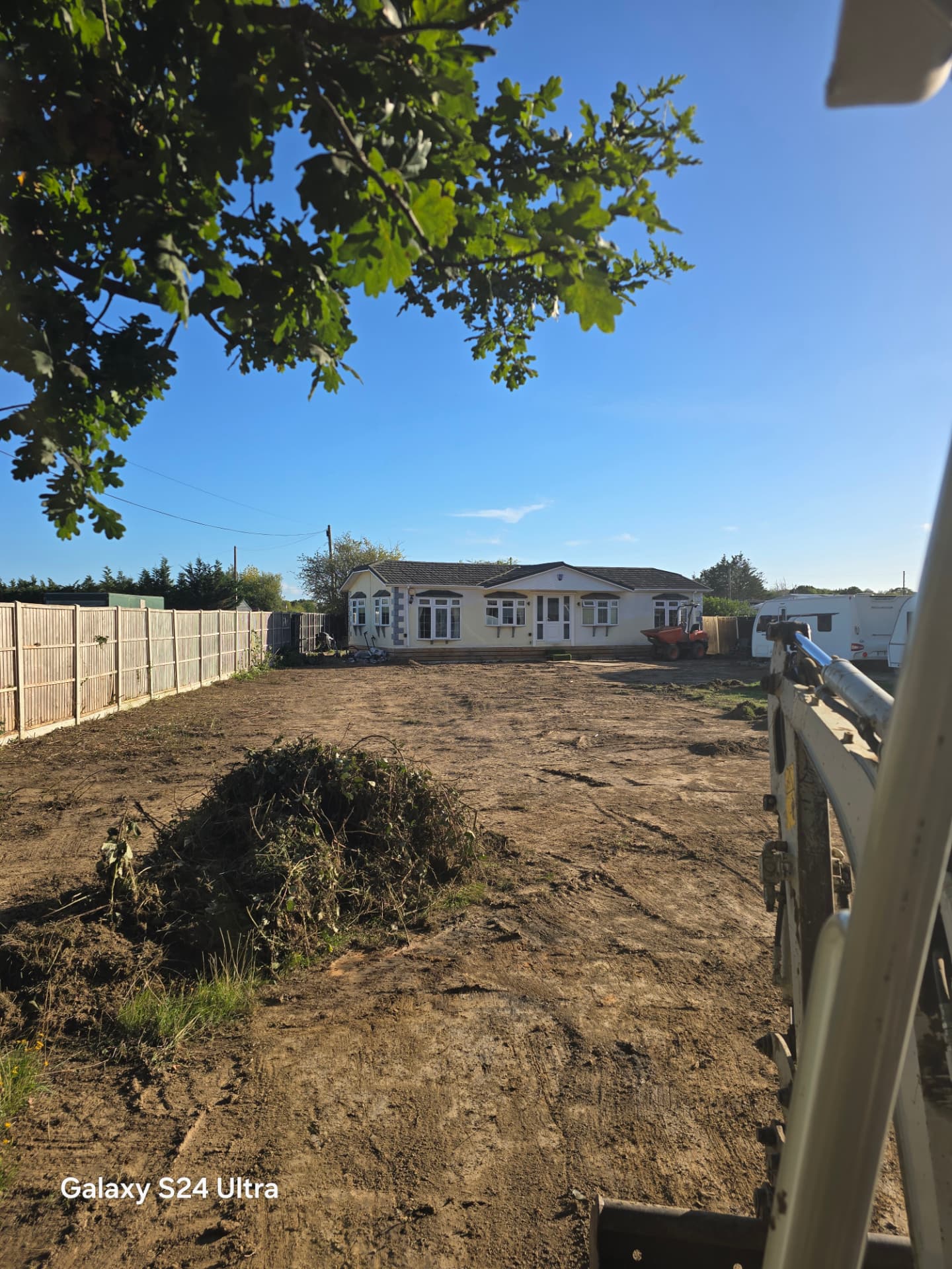 Wide view of stripped and levelled ground with a digger on site near Chichester and Emsworth